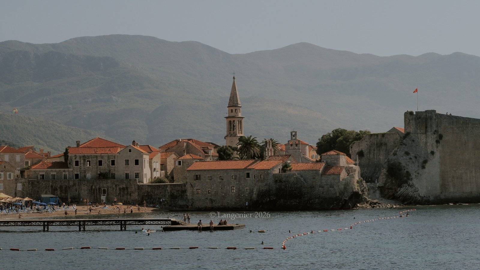 Panoramic view of Budva old town walls and bell tower along the Adriatic Sea, Montenegro