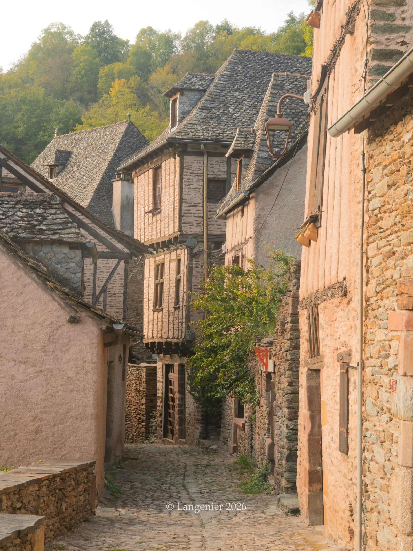 Pretty cobbled street lined with half-timbered houses in the medieval village of Conques, Aveyron, France